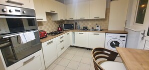 Prepare meals and do laundry in this well-equipped kitchen with a double oven, microwave, and washing machine.