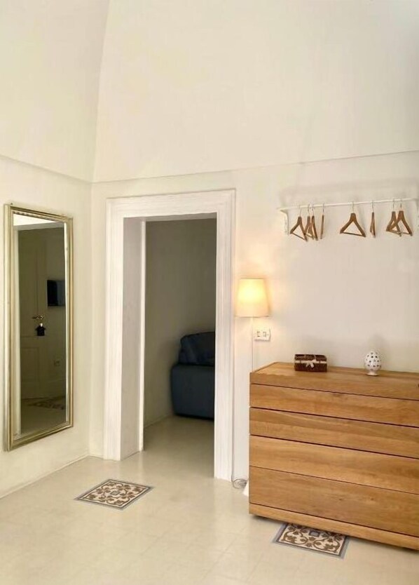 A room with a wooden dresser, a mirror, and a hanging light fixture. - Luxury (Monopoli)