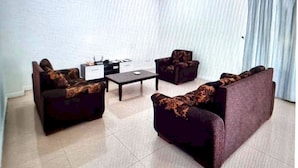 A living room with a sofa set, a coffee table, and a TV. - OYO HOME 90769 Flo Inn Homestay Bsi (Tawau)
