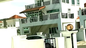 A modern two-story house with a gated entrance and a car parked in the driveway. - OYO HOME 90769 Flo Inn Homestay Bsi (Tawau)