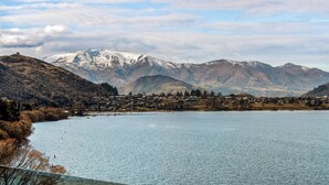 Um lago com montanhas ao fundo e uma cidade do outro lado da água.