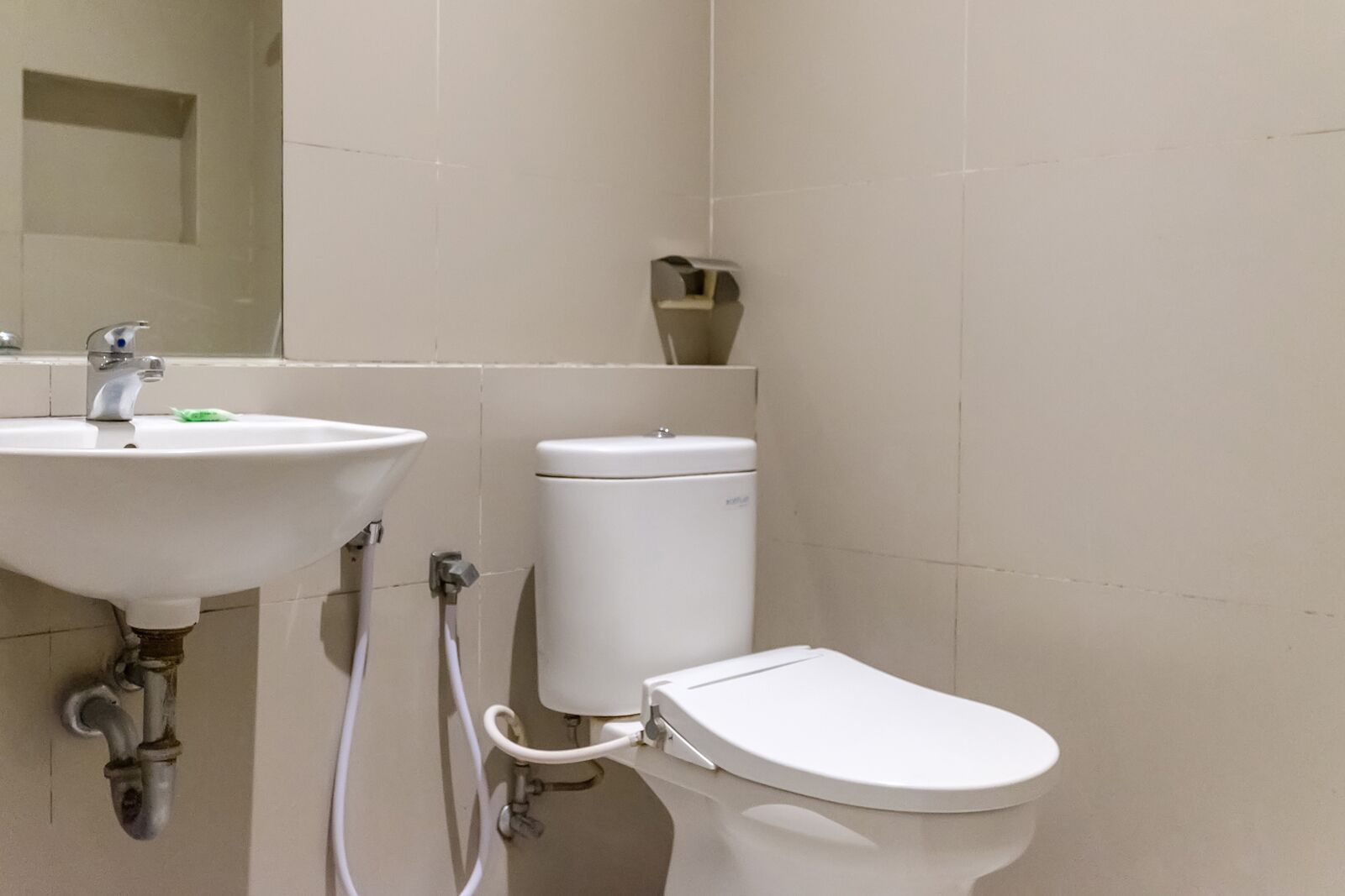 A bathroom with a sink, toilet, and a mirror.
