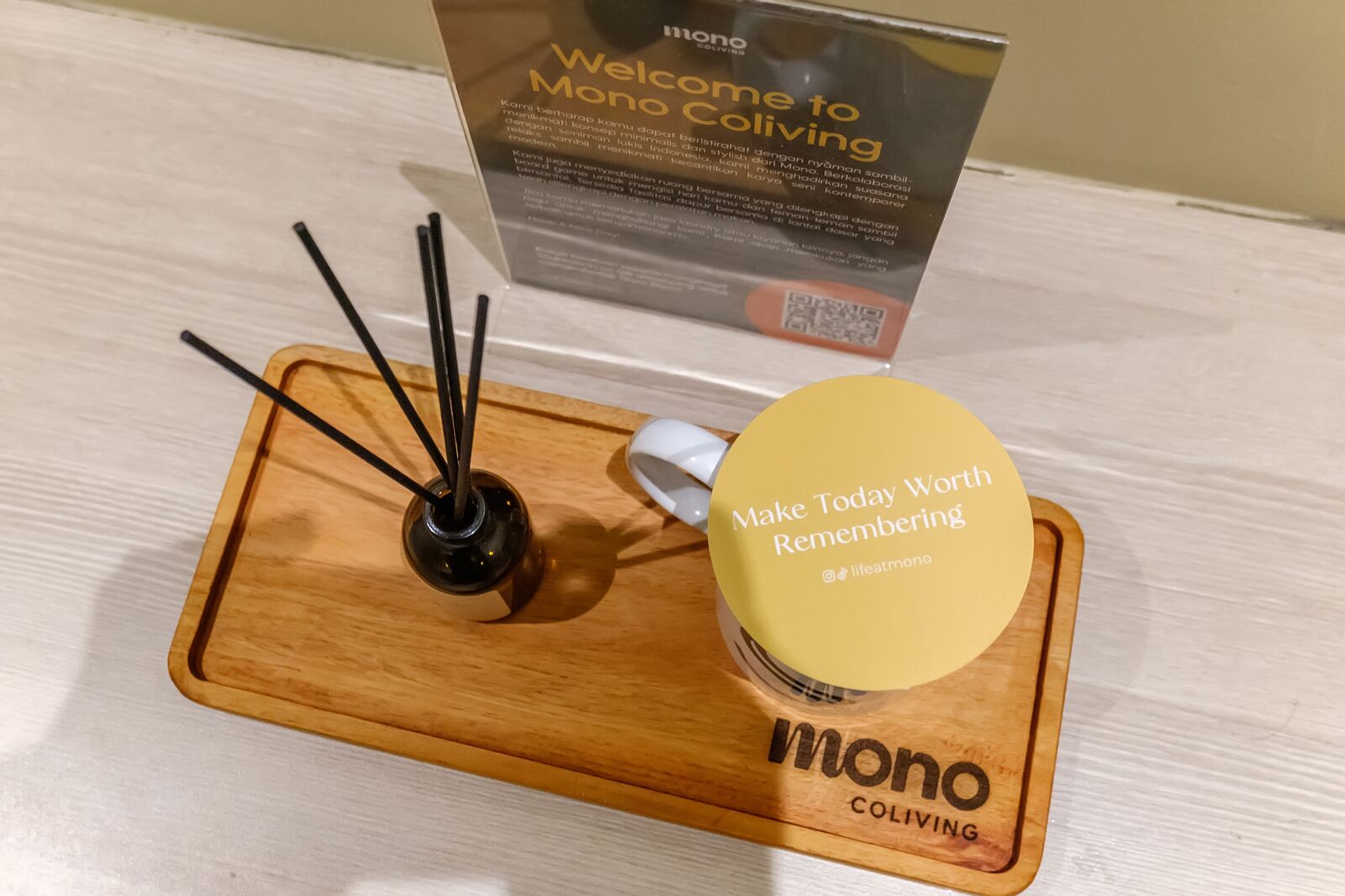 Una bandeja de madera con un frasco de crema para manos y un candelabro negro.
