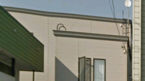A two-story building with a flat roof, two windows on the ground floor, and a satellite dish on the roof. - HONGO 11 HOTEL (Sapporo)