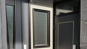 A modern entrance with a glass door, a metal door, and a small window. - HONGO 11 HOTEL (Sapporo)