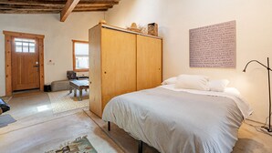 Un dormitorio con cama, armario de madera y una pared con texto.