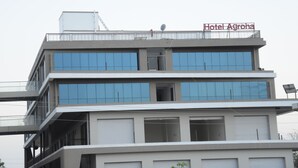 A multi-story hotel with a sign reading "Hotel Agroha" on the top.