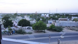 A street view with buildings, trees, and a road.