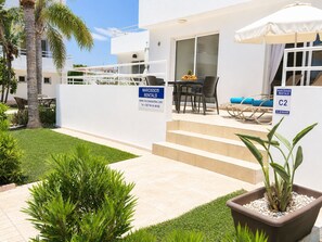 A modern villa with a patio, outdoor seating, and a sign for NARCISSOS RENTALS. - Narcissos Nissi Beach apartment C2 (Ayia Napa)