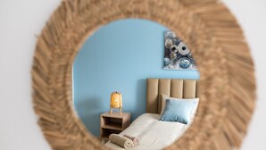Een slaapkamer met een bed, nachtkastje en een wandlamp.