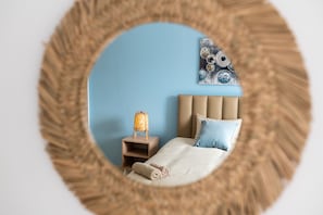 Une chambre à coucher avec un lit, une table de chevet et une lampe fixée au mur.