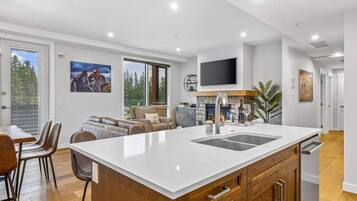 Una cocina moderna con una isla grande, armarios de madera y un televisor integrado.