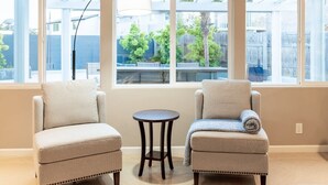 Een kamer met twee fauteuils, een klein rond tafeltje en een vloerlamp.
