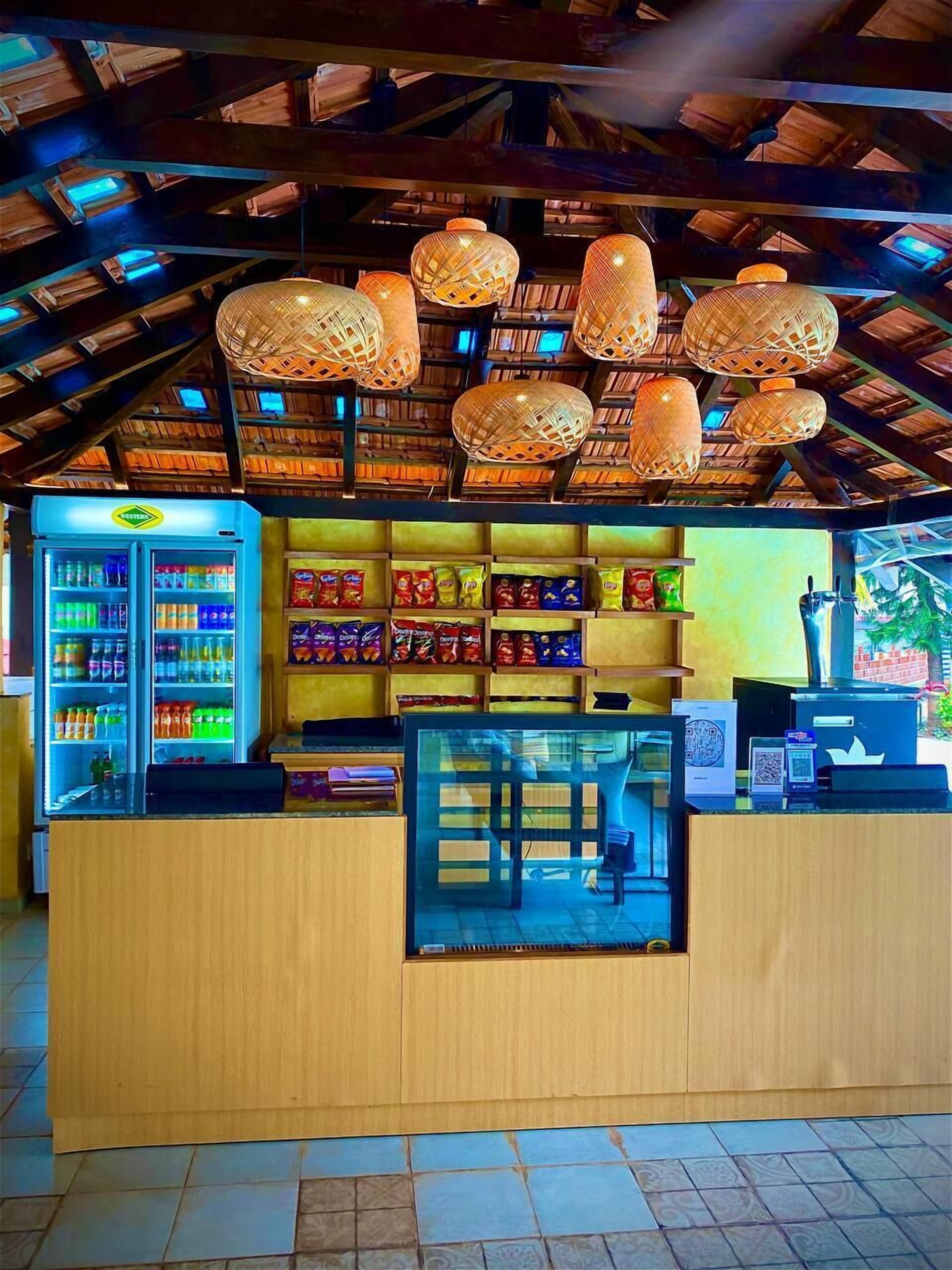 Un kiosque doté d’un comptoir en bois, d’étagères remplies de collations et d’un présentoir réfrigéré.
