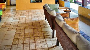 A covered seating area with a wooden ceiling, a counter with snacks, and a refrigerator stocked with beverages. - Indie Stays Goa (Candolim)
