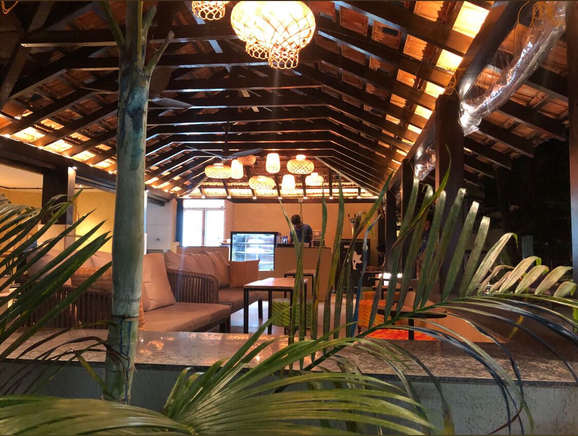 A cozy lounge area with a high ceiling, wooden beams, and a comfortable seating arrangement.