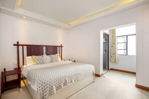 A bedroom with a large bed, wooden headboard, and a bedside table. - Yangshuo Xingping Our Inn-Near 20 Yuan Background (Yangshuo)