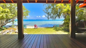Une terrasse en bois offrant une vue sur une plage et l’océan.