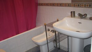 Un baño con inodoro, bidé y lavamanos.
