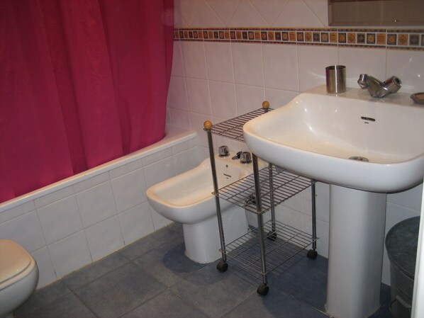 A bathroom with a toilet, bidet, and sink. - Exceptional Apartment with a View in Duquesa (Granada)