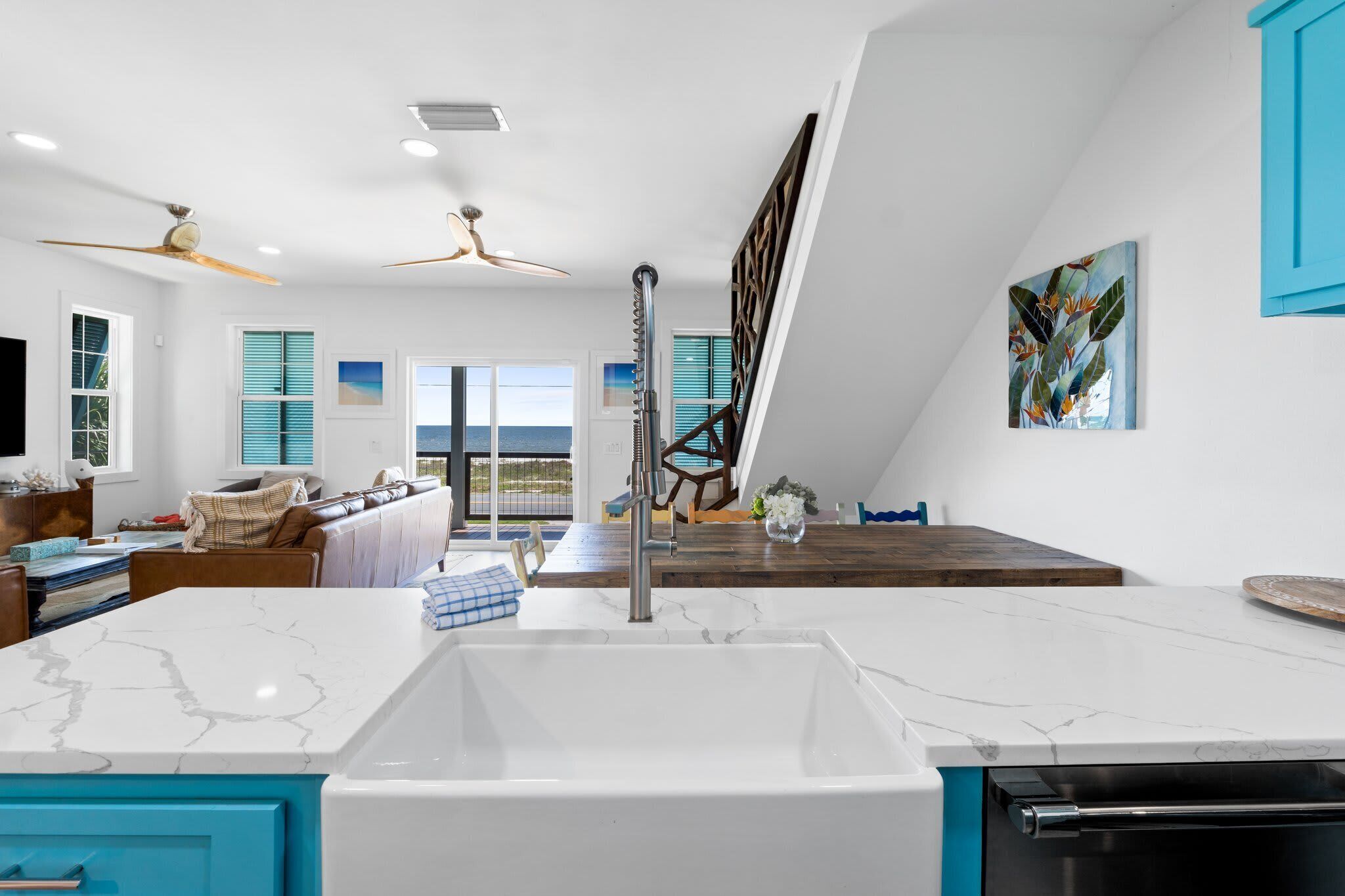 A modern kitchen with a large island, a built-in oven, and a view to the outside.