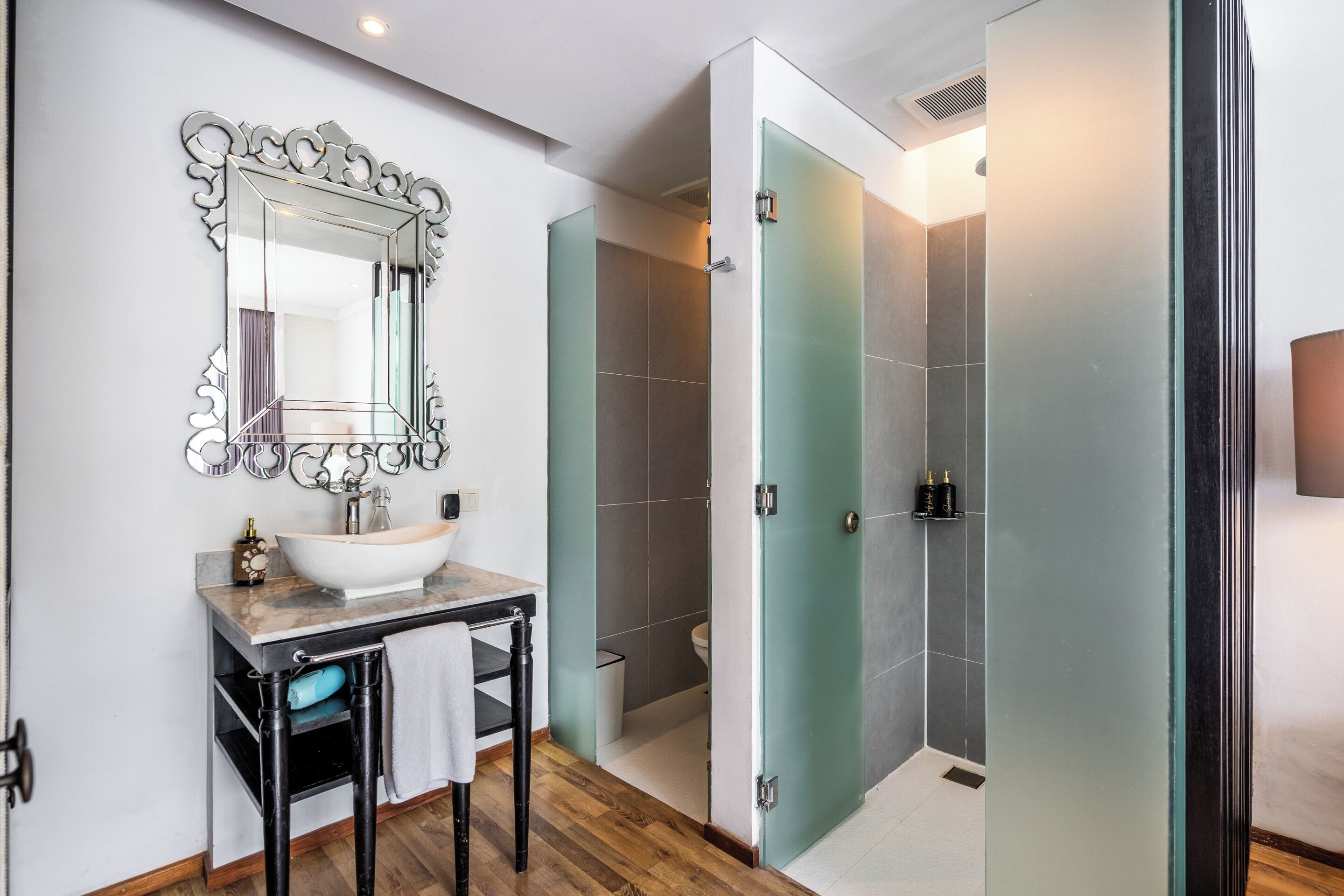 A bathroom with a sink, mirror, and shower.