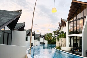 A modern resort with a swimming pool, contemporary architecture, and outdoor seating areas. - Mana Villas Nusa Dua (Nusa Dua)