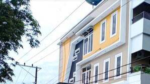 Um edifício de vários andares com área de estacionamento coberta e uma motocicleta estacionada na frente.