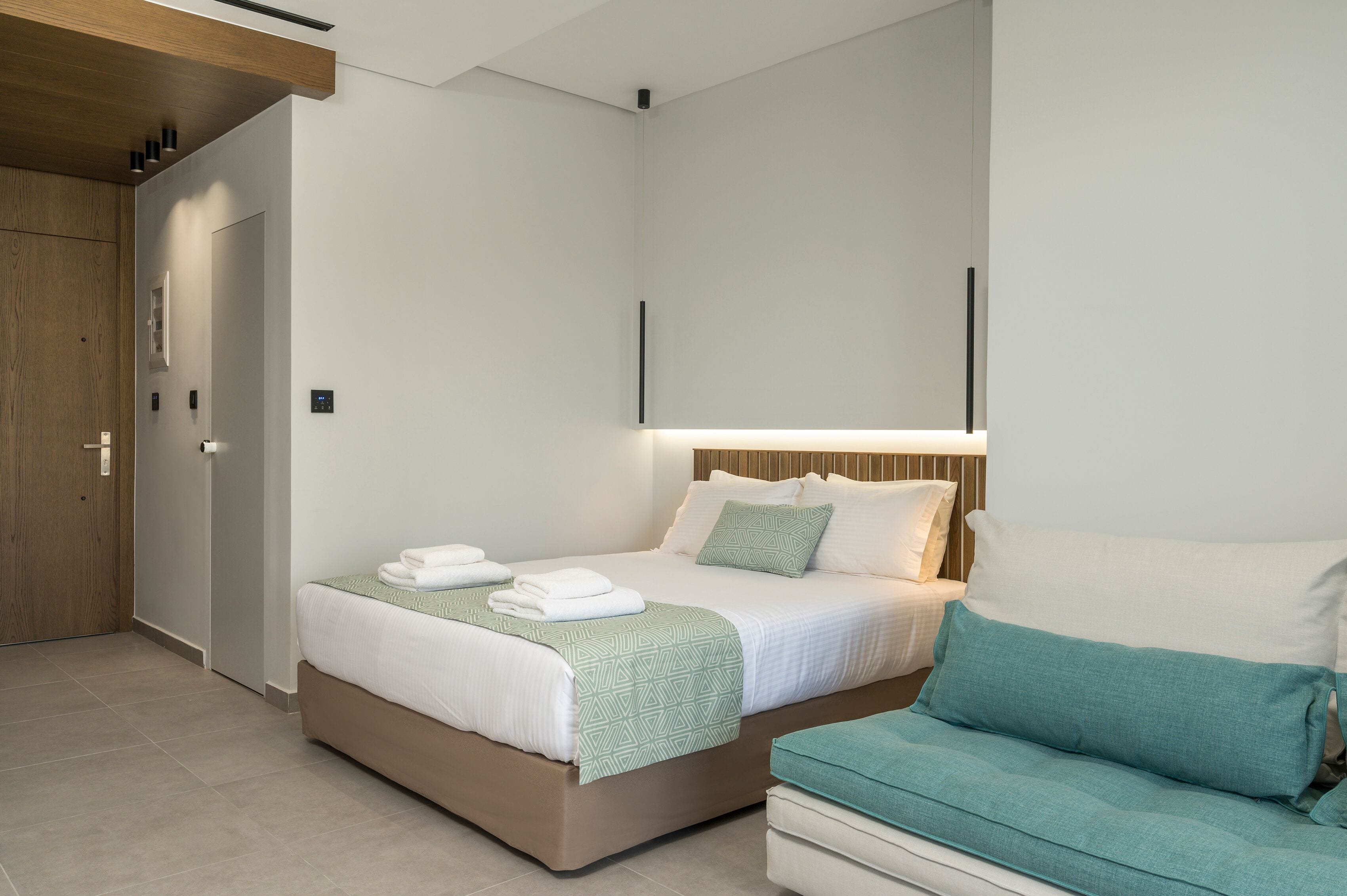 A modern bedroom with a bed, bedside table, and a built-in bench.