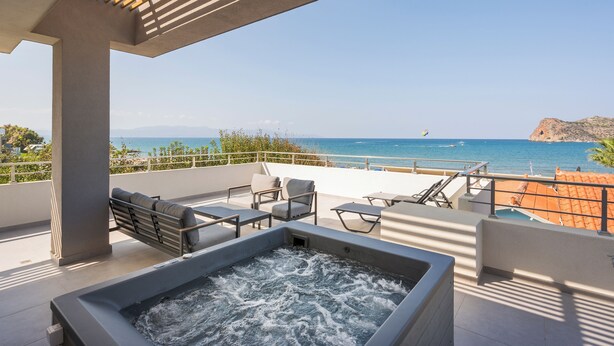 A rooftop terrace with a hot tub, outdoor seating, and a view of the sea. - Ostrakon Suites (Agia Marina)