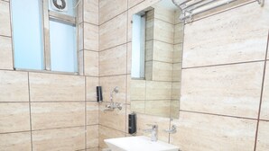 A bathroom with a sink, mirror, and toilet. - Wedlock Hotels (Gurugram)