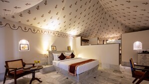 Una camera d'albergo con un letto, un divano, un tavolino e una sedia.