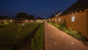Un sentiero conduce a una fila di stanze con un giardino su un lato.