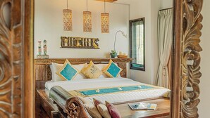 A well-appointed bedroom with a large bed, decorative wall hanging, and a unique ceiling light fixture. - Cempaka Villa by Premier Hospitality (Nusa Dua)