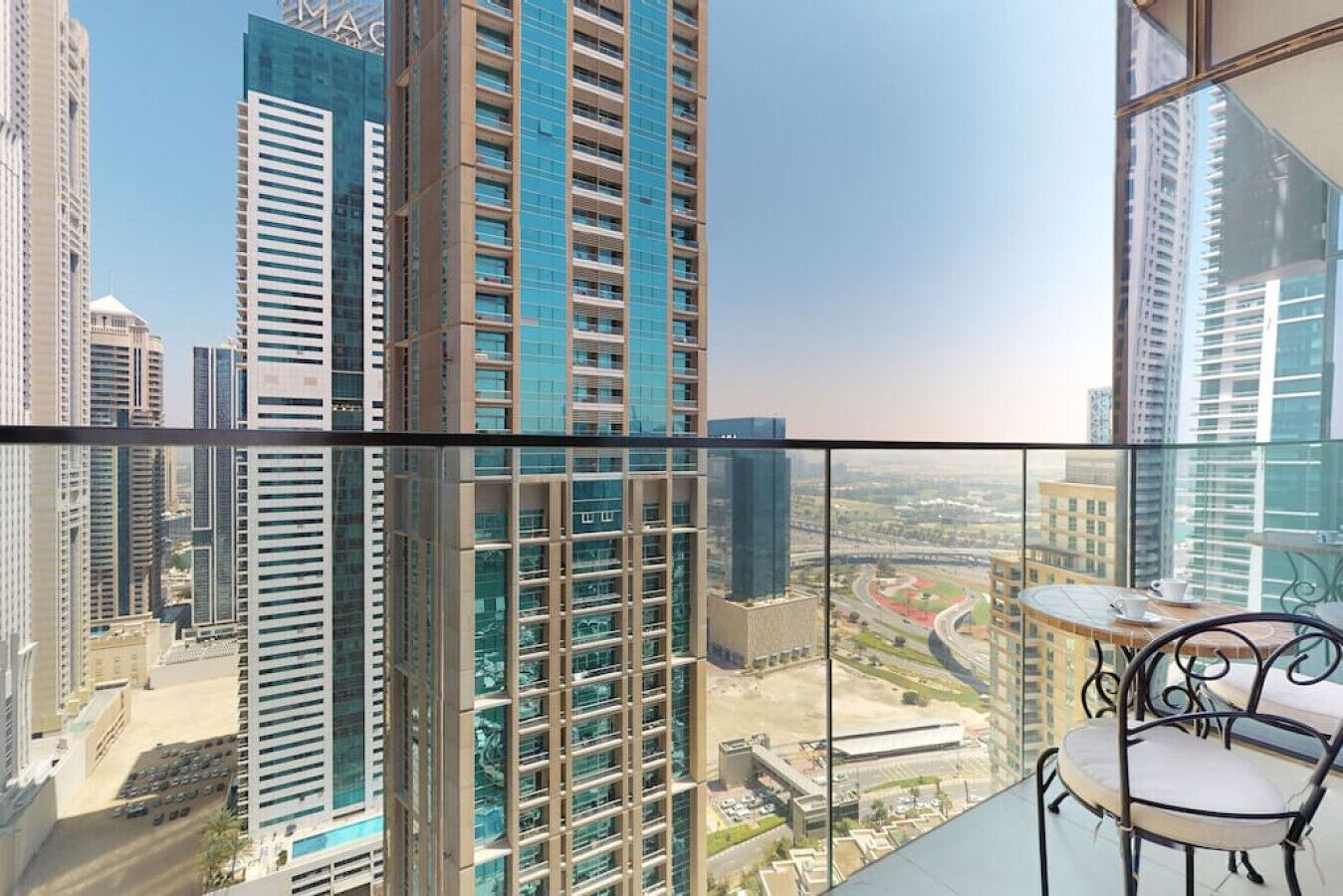 A high-rise building with a view of a cityscape, including a highway and other buildings.