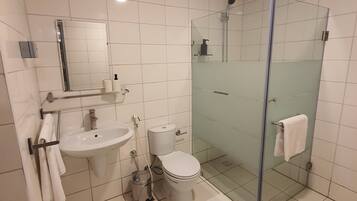 Un baño moderno con ducha envuelta en vidrio, lavamanos y un inodoro.