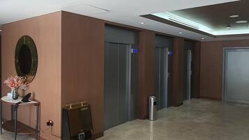 Un vestíbulo moderno con un mostrador de recepción, un espejo grande y un cesto de basura.