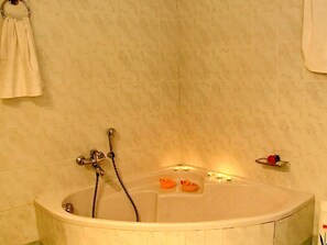 A bathtub with two rubber ducks, a towel ring, and a small shelf with a fruit. - Private property with outdoor pool , cosy spaces and beautiful garden (Kato Archanes)