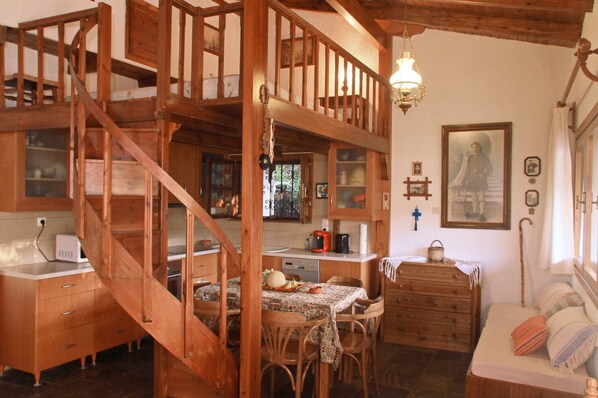Una cocina rústica con muebles de madera, un comedor y una escalera.