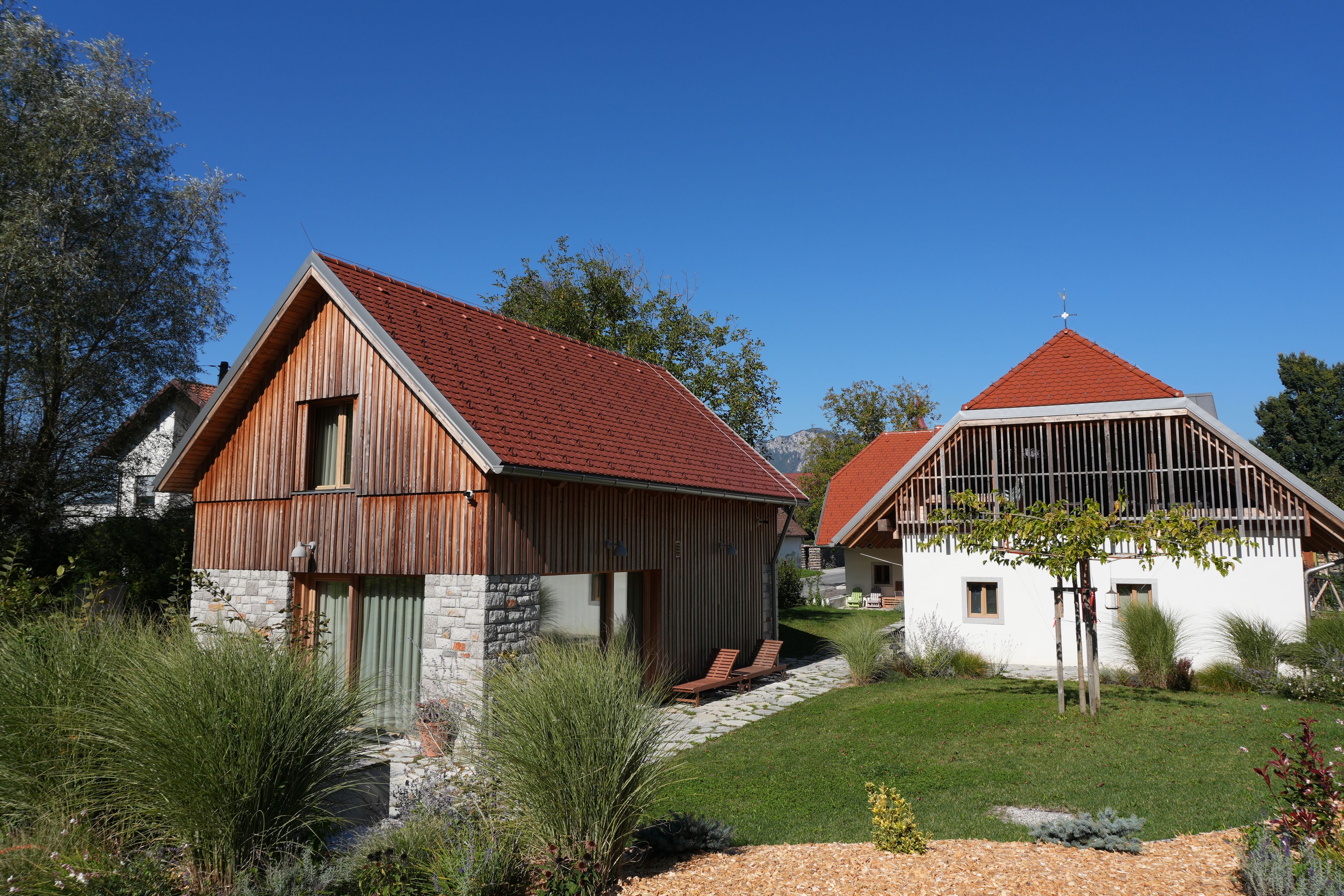 A rural property with two wooden buildings, one with a stone foundation and the other with a white exterior.
