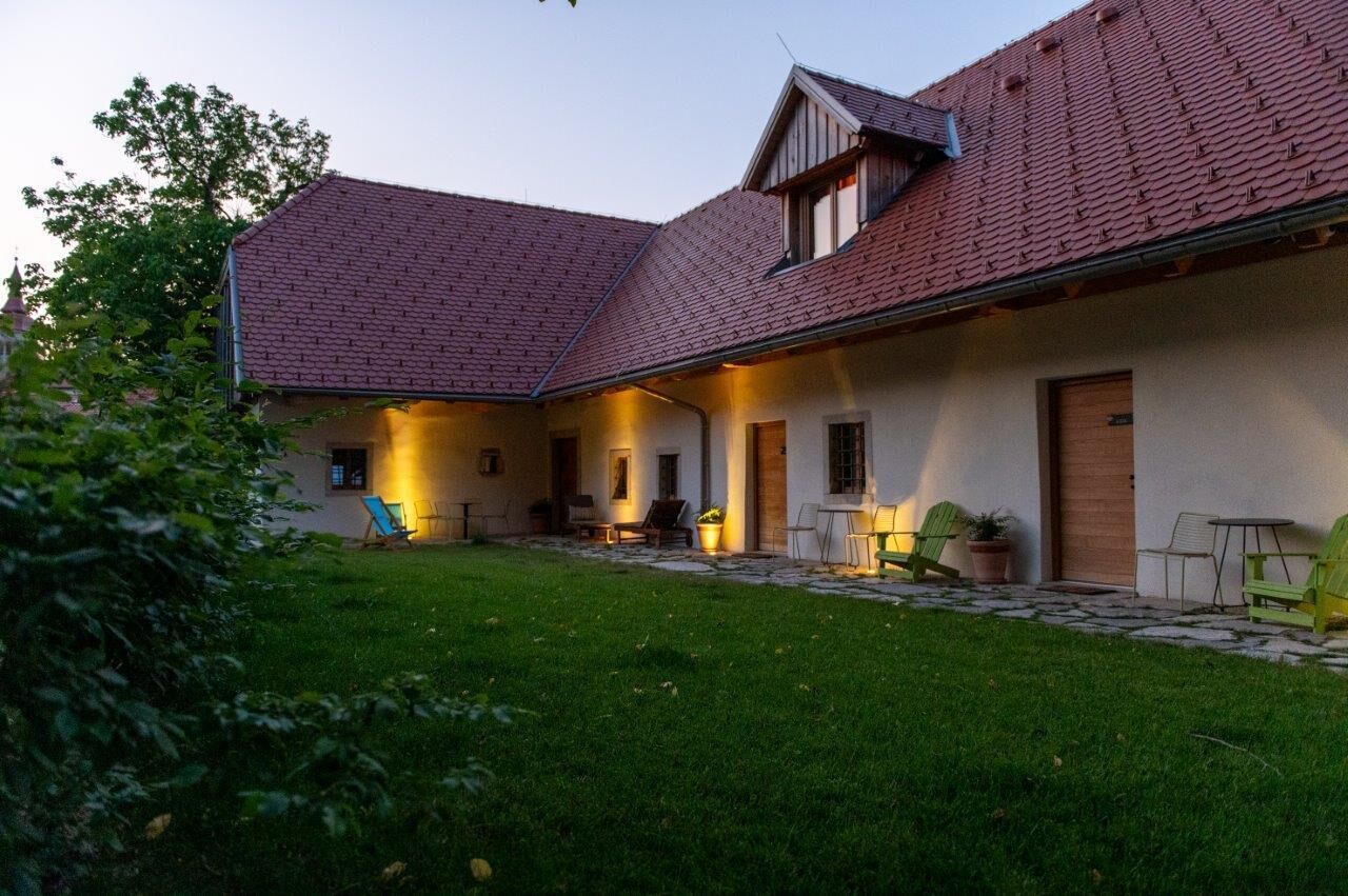 A house with a sloped roof, a covered patio area, and a well-maintained lawn.