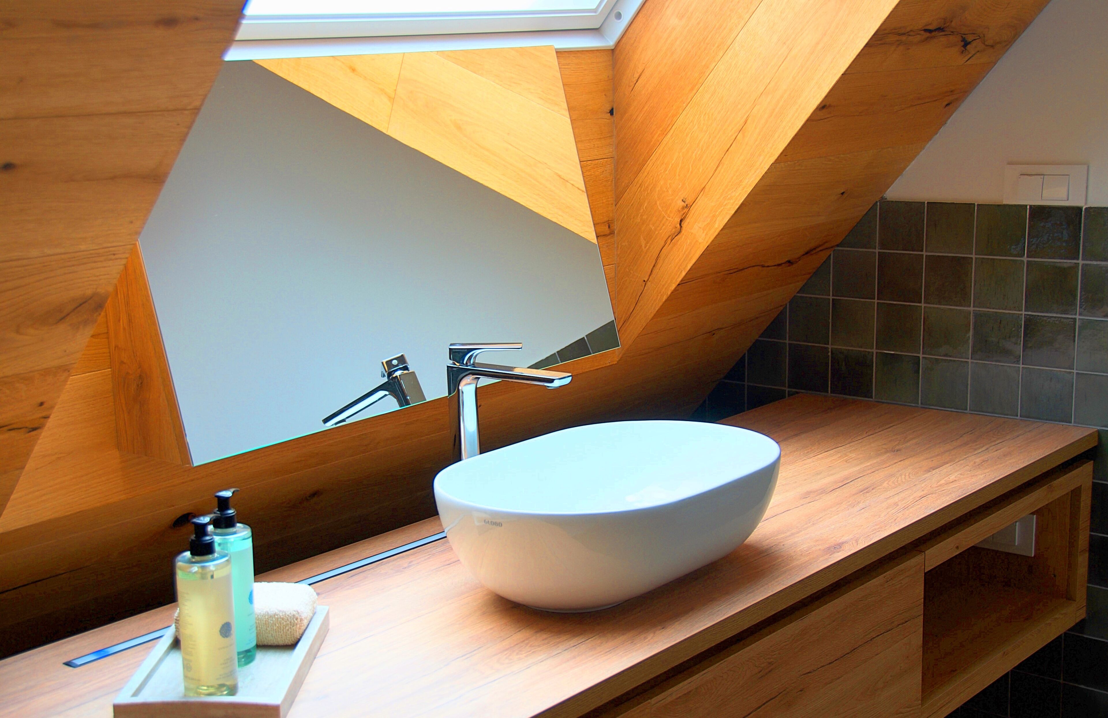 A modern bathroom with a skylight, a white vessel sink, and wooden cabinetry.