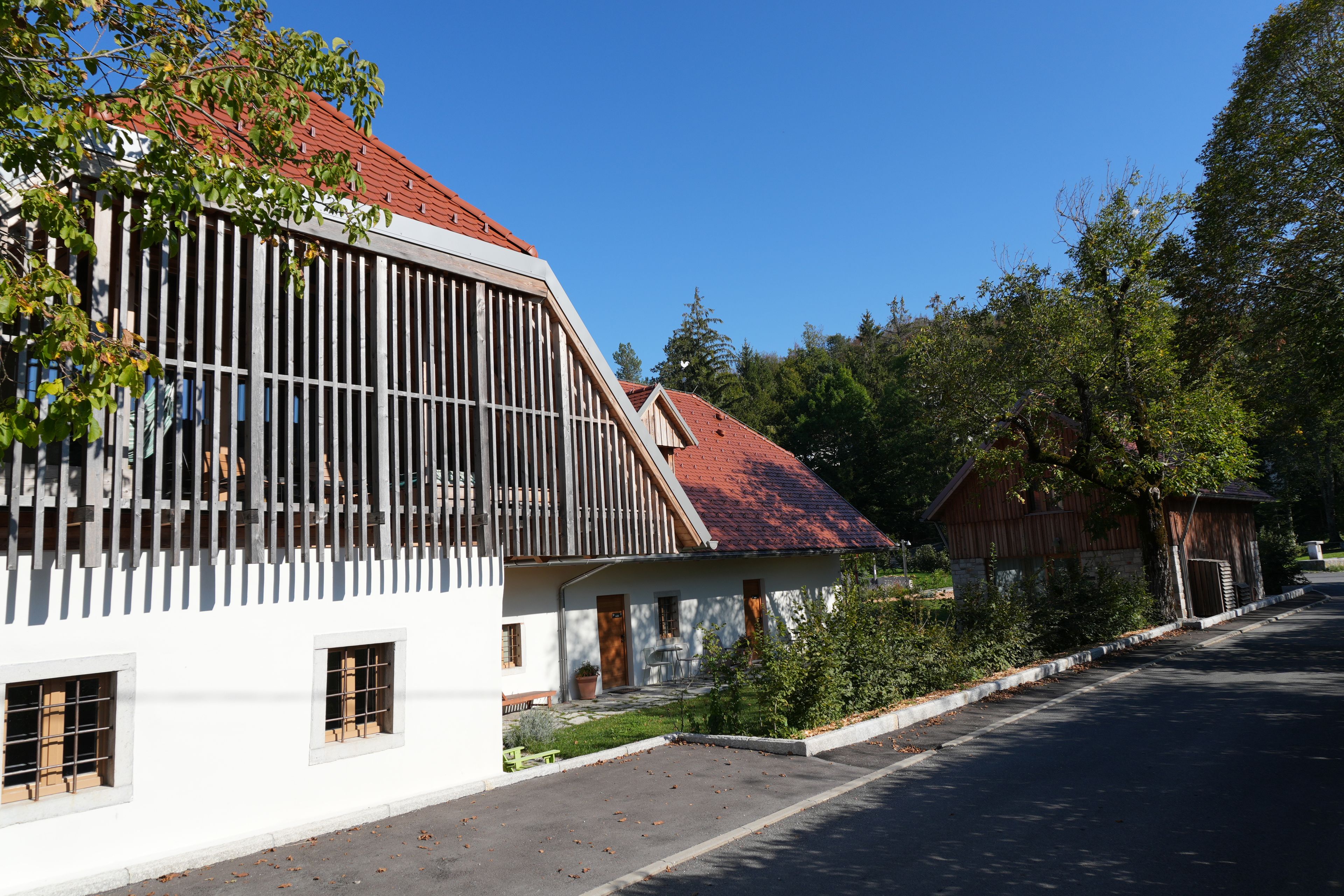 A building with a sloped roof, large windows, and a white facade.