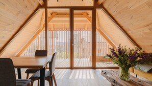 A wooden interior with a dining table and chairs, a wooden bench, and a vase with flowers. - Pira Hotel (Postojna)