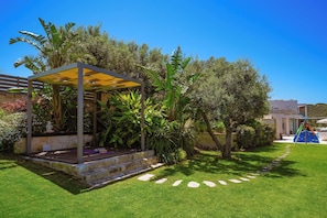 A garden with a pergola, stone steps, and a playground.