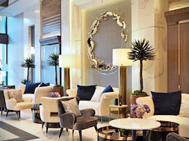 A modern lobby with sofas, armchairs, and a round table.