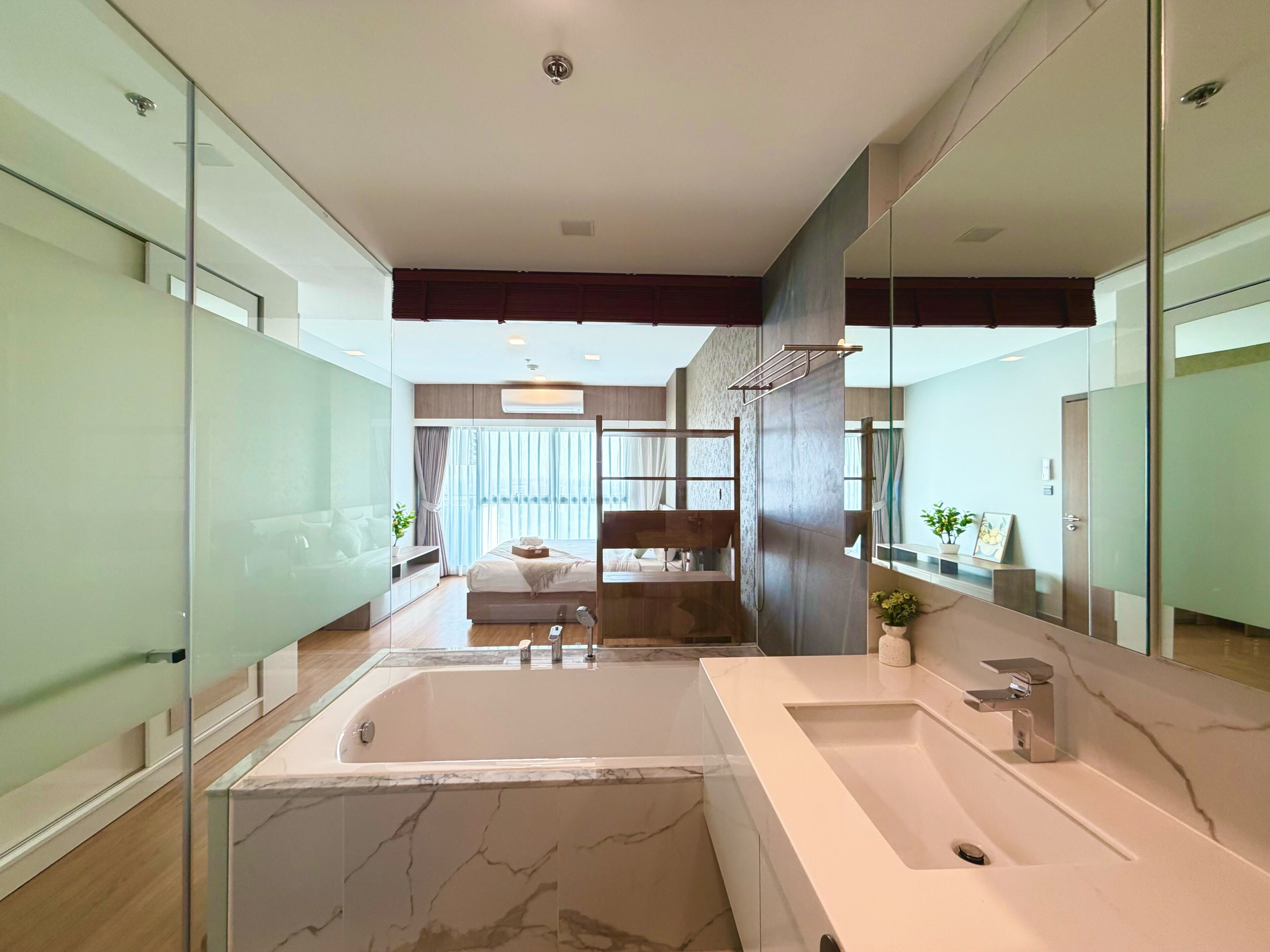 Een moderne badkamer met een groot bad, een aparte wastafel en een douche.