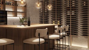 A modern bar area with a wooden counter, bar stools, and a wine rack against a textured wall. - Salento Winery Lodge - Your Wellness Oasis in Salento (San Pietro In Bevagna)