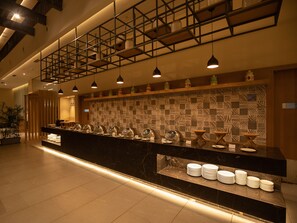 A hotel reception area with a marble counter, multiple light fixtures, and a patterned wall. - The Vern at BLVD (Nashik)