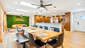 Una cocina moderna con armarios de madera, una isla central e iluminación colgante.